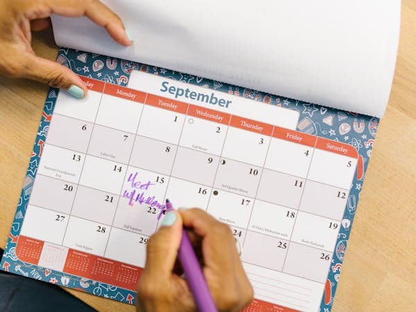Person marking important dates on a calendar
